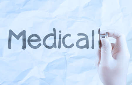 hand hold  stethoscope showing medical concept on crumpled paper backgroundの写真素材