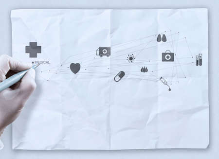 doctor hand draws medical network on crumpled paper as  conceptの写真素材