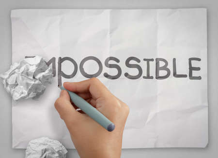  crumpled paper hiding word impossible transformed into possible as conceptの写真素材