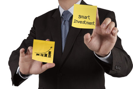 businessman hand showsmart investment  words on sticky note with white background as conceptの写真素材
