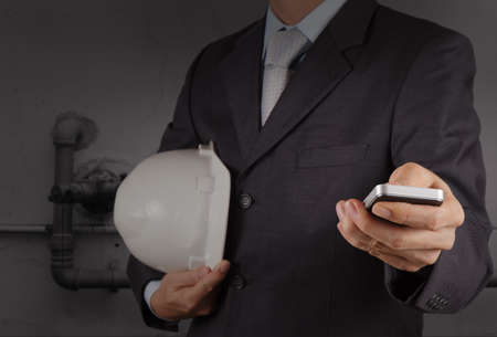 businessman hand use smart phone computer with pipe factory background の写真素材