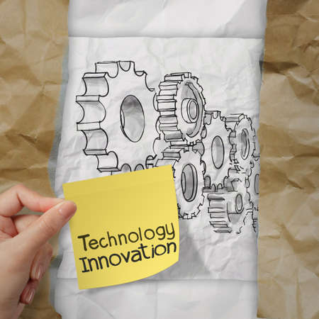 hand holding innovation on sticky note with gear to success concept on crumpled paper の写真素材