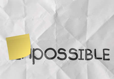 sticky note over word impossible transformed into possible as conceptの写真素材
