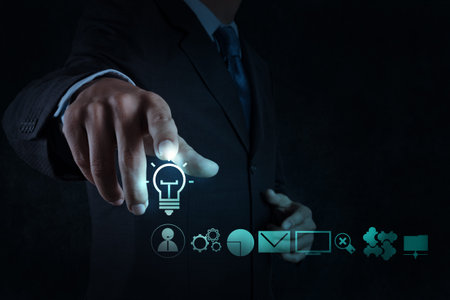 businessman hand draws lightbulb with new computer interface as solution business concept