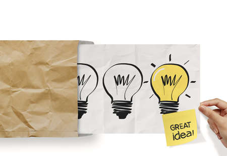 hand pull crumpled paper show light bulb out of recycle envelope as conceptの写真素材
