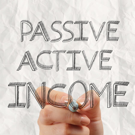 close up of hand drawing passive or acctive income as concept