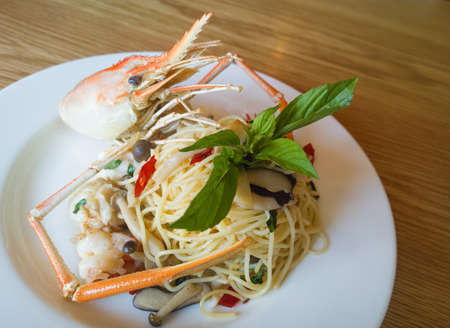italian spaghetti pasta and fresh spicy shrimps sauce on wooden tableの写真素材