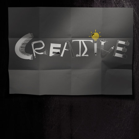 design word CREATIVE on dark crumpled paper and texture background as concept
