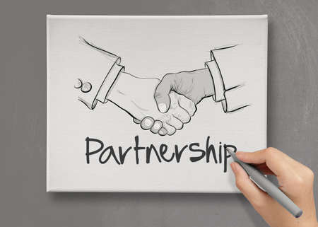 hand drawn handshake sign on canvas board as partnership business conceptの写真素材