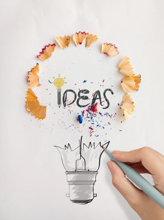 hand drawn light bulb word design IDEA with pencil saw dust on paper as creative concept