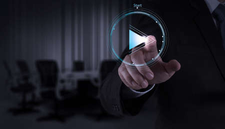 Businessman hand press play button sign to start or initiate projects as conceptの写真素材