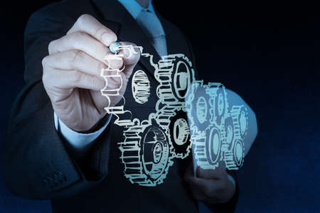 businessman hand draws gear to success conceptの写真素材