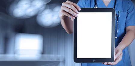 Doctor working with tablet computer with operating roomの写真素材