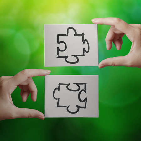 Hand holding hand drawn  Partnership Puzzle icon on cavas board as concept の写真素材