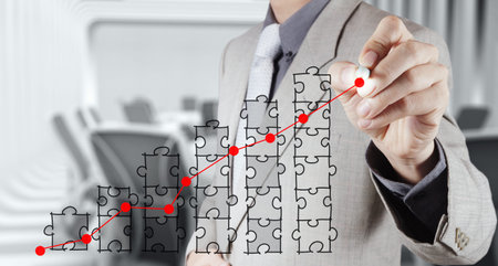 businessman hand puzzle charts with new modern computer and business strategy as conceptの写真素材