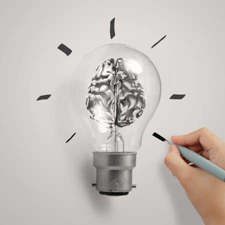 hand with 3d metal human brain in a light bulb as creative concept の写真素材