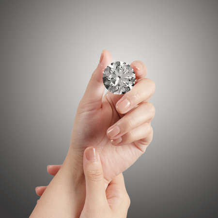 hand holding 3d diamond over grey backgroundの写真素材