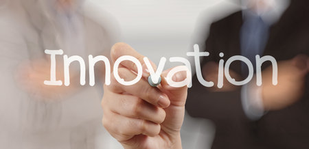 businessman hand writing innovation on touch screen computer as concept