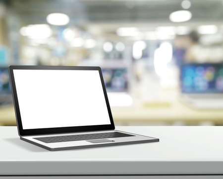 Laptop with blank screen on laminate table and blurred background