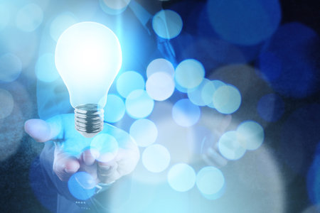 Businessman hand working with 3d light bulb of leadership concept and bokeh exposureの写真素材