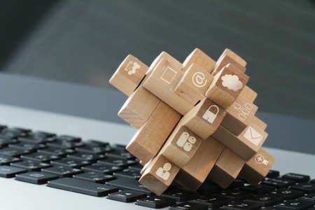wooden cubes with technology icons on computer as cloud network conceptの写真素材