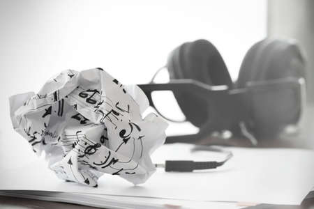 composing music concept with shallow DOF evenly matched jack of headphone and crumpled musical notes paperの写真素材