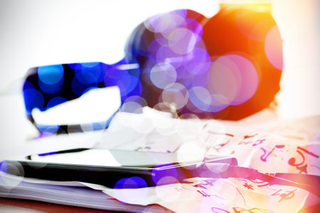 double exposure of abstract blurry bokeh with smartphone with headphone on musical notes paper with...