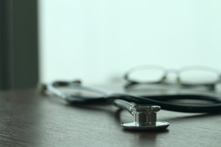 Studio macro of a stethoscope and glasses with shallow DOF evenly matched abstract on wood table...