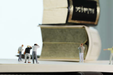 Creative idea concept - miniature photographer with vintage golden book on open paper notebookの写真素材