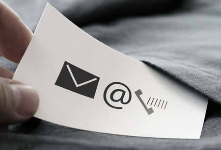 close up of businessman hand picking business card icon contact us concept from the pocket of gray suit jacket backgroundの写真素材