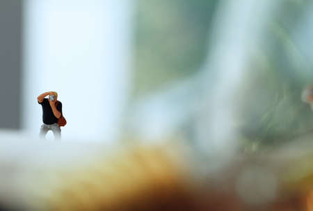 Creative idea concept - miniature photographer with vintage light bulb on open paper notebookの写真素材