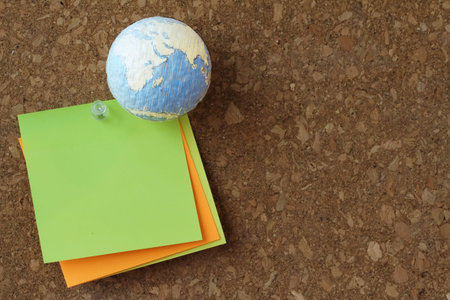 hand drawn texture globe  with pin and sticky note on cork board as concept