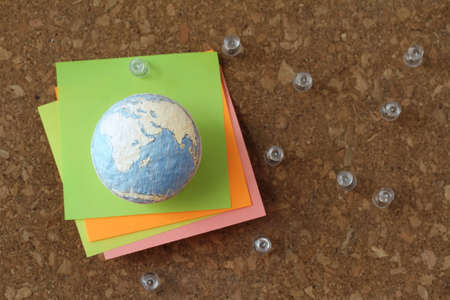 hand drawn texture globe and social network diagram with pin and sticky note on cork board as conceptの写真素材