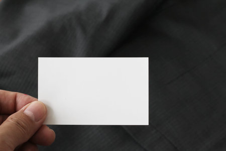 Blank corporate identity package business card with dark grey suit background.