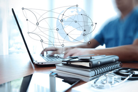 Doctor working with laptop computer in medical workspace office and medical network media diagram as...