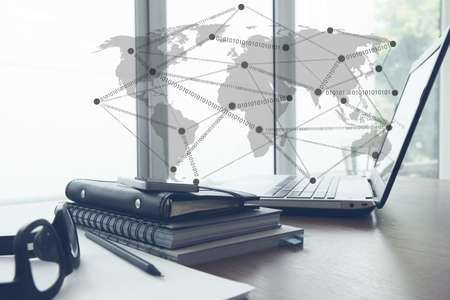 Office workplace with laptop and smartphone with social network diagram on wooden desk as conceptの写真素材