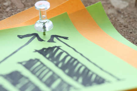close up of pin and hand drawn business strategy graph chart on sticky note with cork board as conceptの写真素材