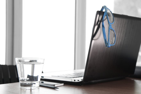 Office workplace with laptop and smartphone on wood table