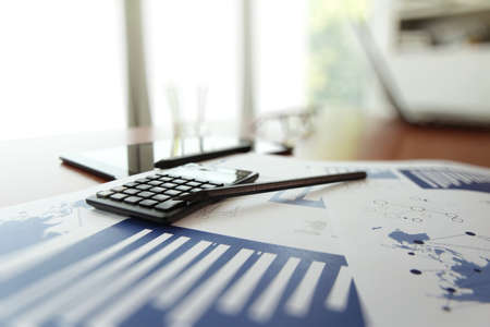 business documents on office table with calculator and digital tablet as work space business conceptの写真素材