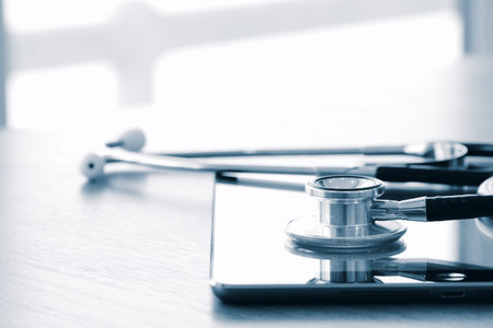 Studio macro of a stethoscope and digital tablet with shallow DOF evenly matched abstract on wood...