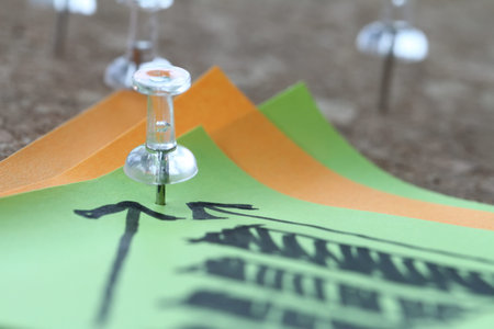 close up of pin and hand drawn business strategy graph chart on sticky note with cork board as conceptの写真素材