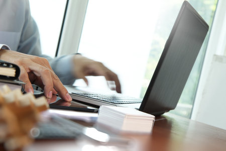 Close up of business man hand working on  laptop computer with social media diagram on wooden desk...