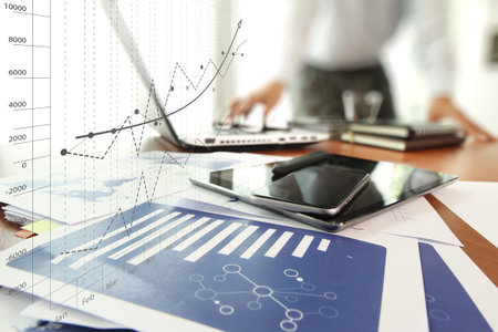 business documents on office table with smart phone and digital tablet and graph business diagram...