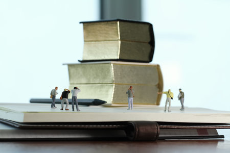 Creative idea concept - miniature photographer with vintage golden book on open paper notebookの写真素材