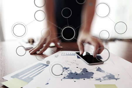 business documents on office table with smart phone and digital tablet and  blank flow chart with man working in the backgroundの写真素材