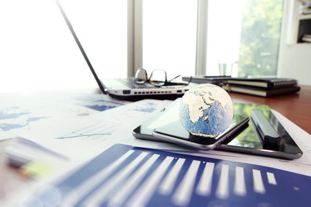 business documents on office table with texture the world on smart phone and digital tablet as work space business concept Elements of this image furnished by NASAの写真素材