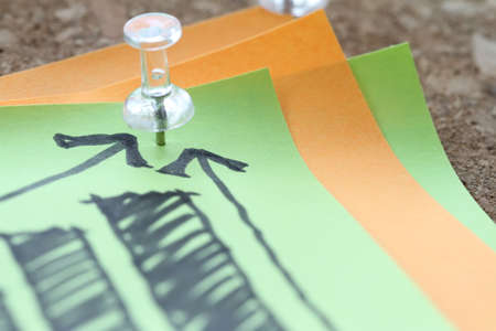 close up of pin and hand drawn business strategy graph chart on sticky note with cork board as conceptの写真素材