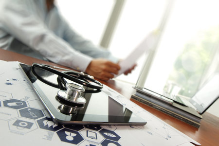 Doctor working with digital tablet and laptop computer in medical workspace office and medical...
