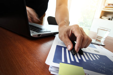 Young creative designer man working at office and social network media and graph chart diagram as conceptの写真素材