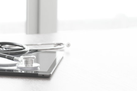 studio macro of a stethoscope and digital tablet on wood table background copy space